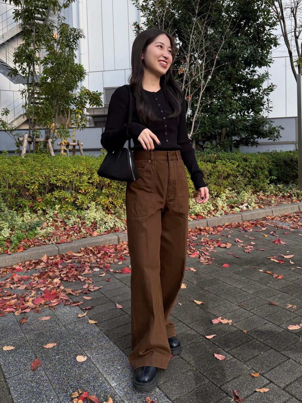 ブラック系のニット/セーター、ブラウン系のテーラードジャケット、ブラウン系のその他パンツを着用したレディースの秋コーディネートの3枚目の写真