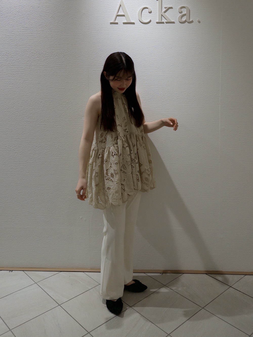 ベージュ系のトップス、ホワイト系のパンツ、ブラック系のパンプスを着用したレディースの春コーディネートの4枚目の写真