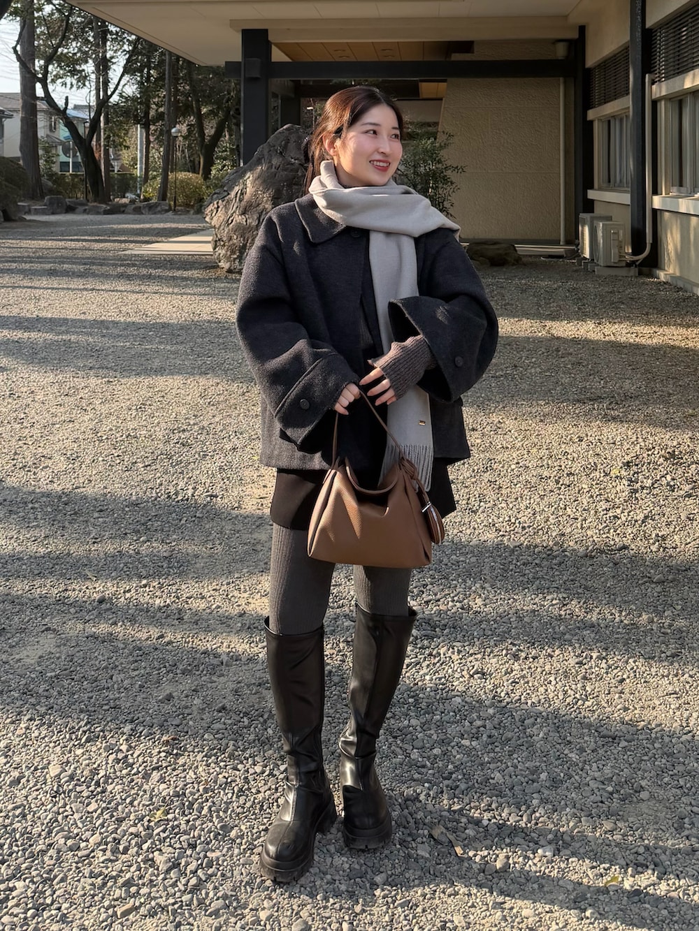 ブラック系のその他パンツ、グレー系のニット/セーター、イエロー系のハンドバッグを着用したレディースの冬コーディネートの4枚目の写真