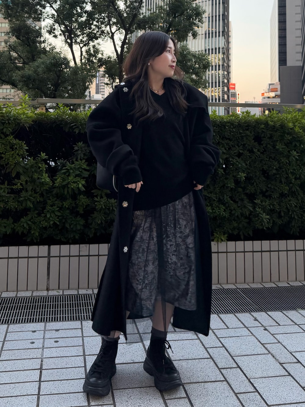 ブラック系のニット/セーター、ブラック系のその他アウター、シルバー系のワンピースを着用したレディースの秋コーディネートの2枚目の写真