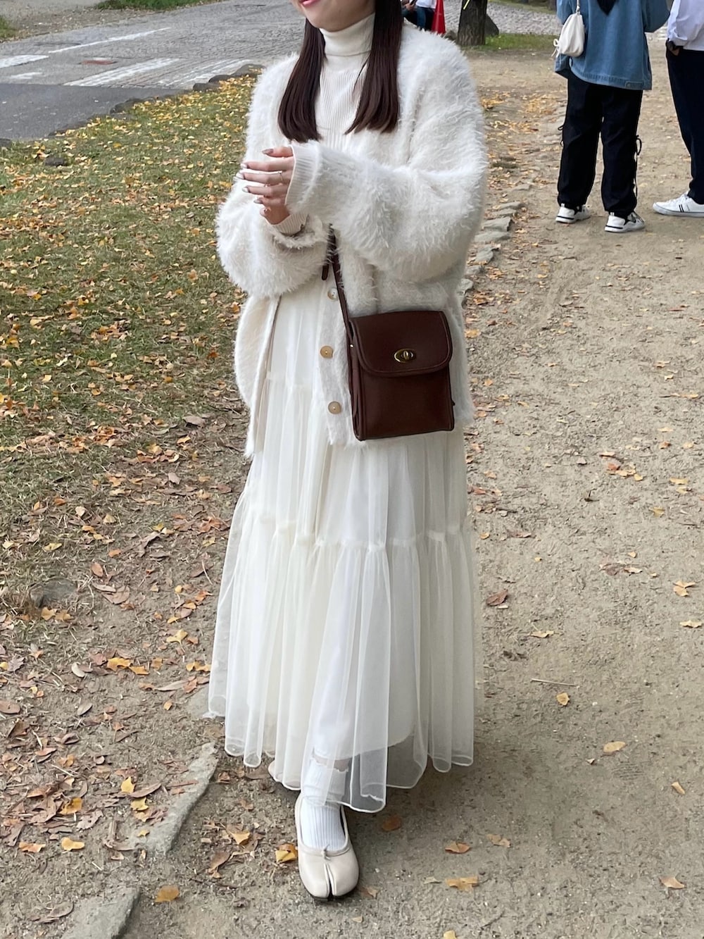 ホワイト系のニット/セーター、ホワイト系のカーディガン/ボレロ、ホワイト系のスカートを着用したレディースの秋コーディネートの3枚目の写真