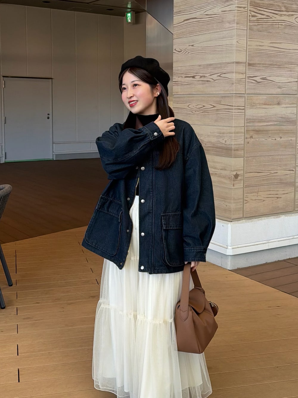 ブルー系のデニムジャケット、ブラック系のニット/セーター、ホワイト系のスカートを着用したレディースの冬コーディネートの3枚目の写真