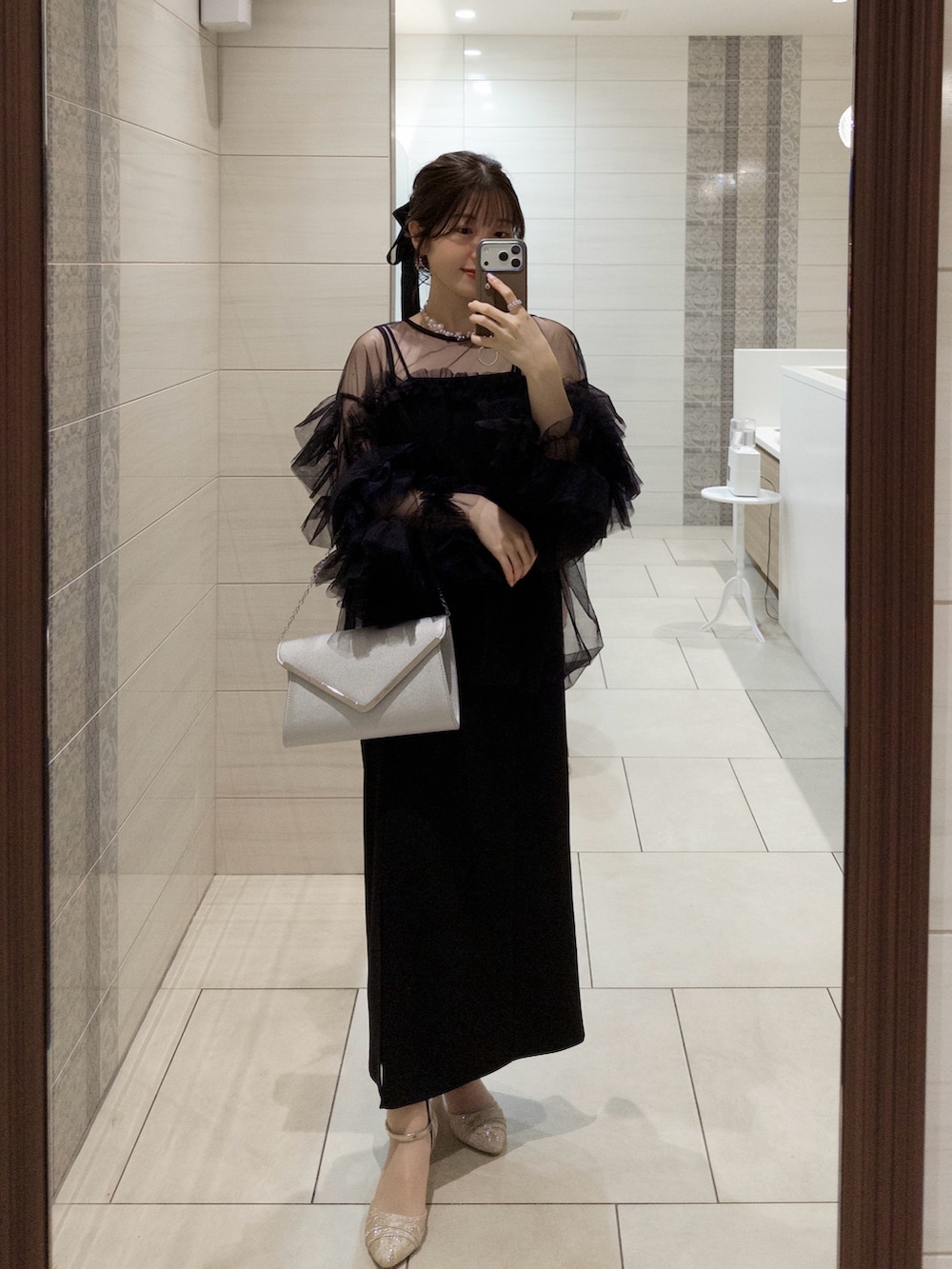 ブラック系のシャツ/ブラウス、シルバー系のハンドバッグ、ゴールド系のパンプスを着用したレディースの夏コーディネートの4枚目の写真