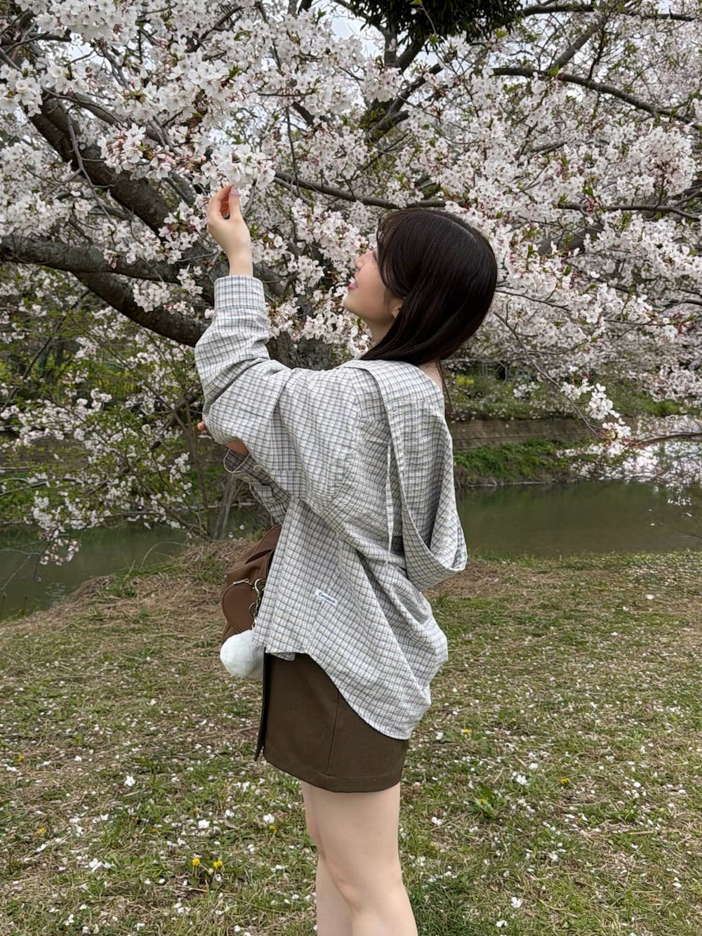 ベージュ系のシャツ/ブラウス、ホワイト系のキャミソール、ブラウン系のスカートを着用したレディースの春コーディネートの2枚目の写真