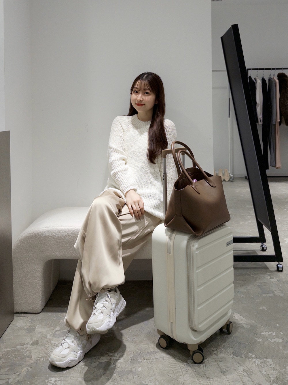 ブラック系のニット/セーター、ベージュ系のその他パンツ、ホワイト系のスニーカーを着用したレディースの秋コーディネートの5枚目の写真
