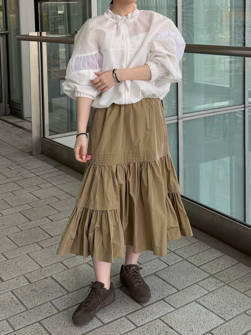 ホワイト系のキャミソール、ホワイト系のブルゾン、ベージュ系のスカートを着用したレディースの春コーディネートの3枚目の写真
