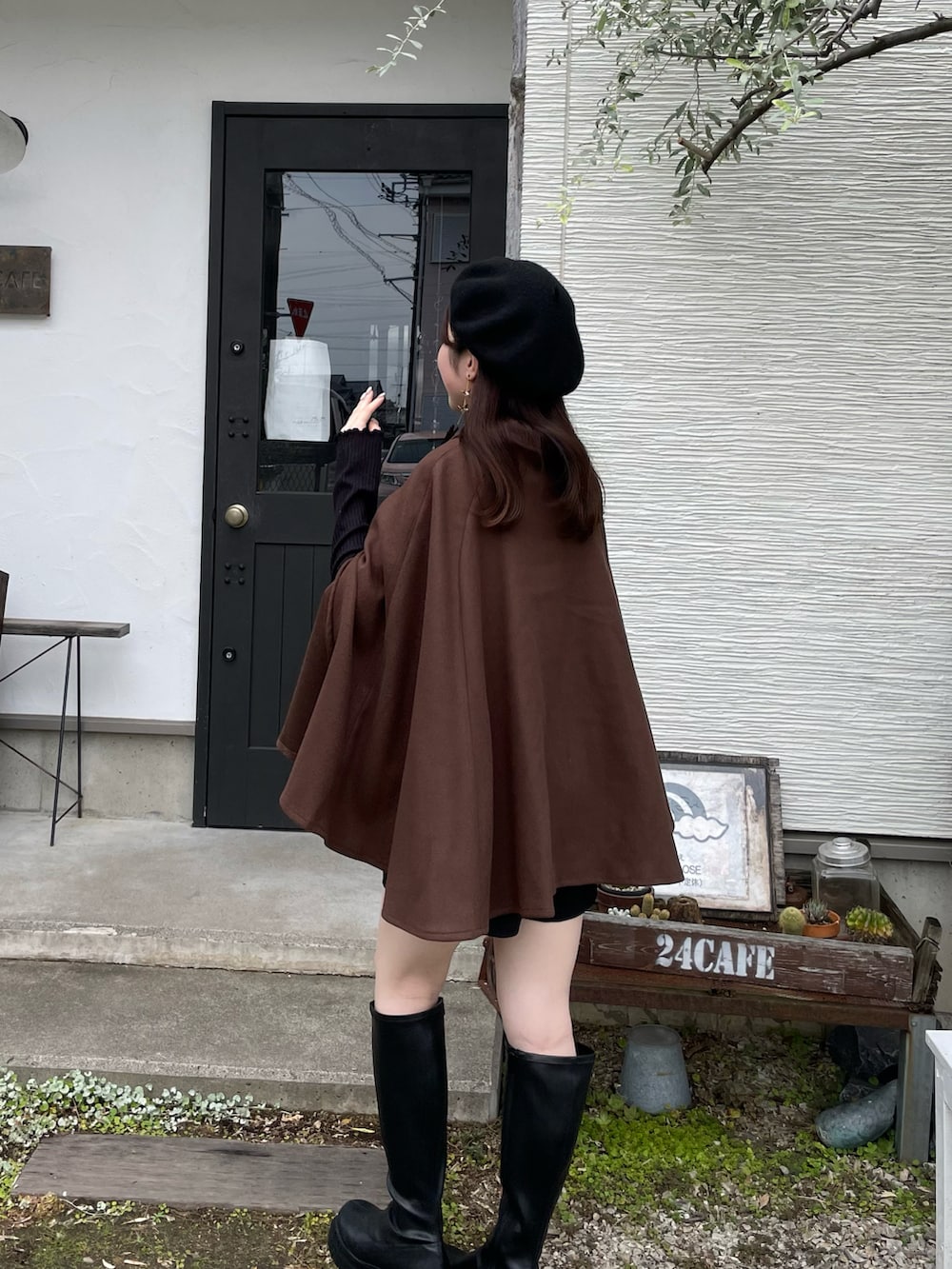 ブラウン系のポンチョ、ブラック系のその他パンツ、ブラック系のブーツを着用したレディースの秋コーディネートの2枚目の写真