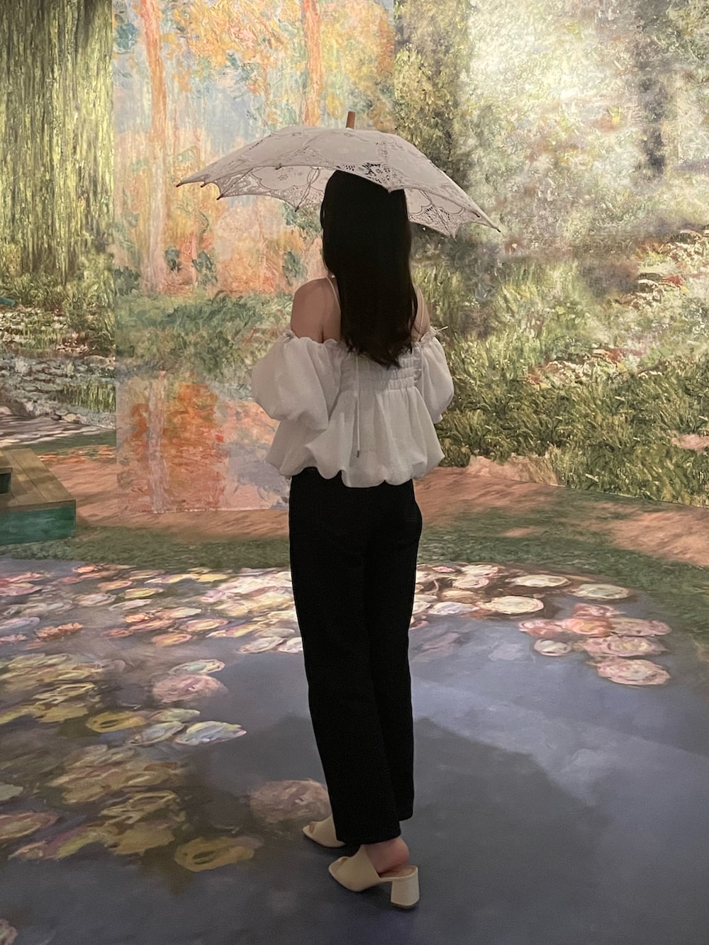 ホワイト系のシャツ/ブラウス、ブルー系のパンツ、ホワイト系のサンダルを着用したレディースの夏コーディネートの3枚目の写真