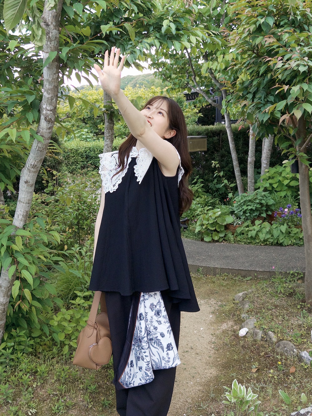 ブラック系のその他パンツ、イエロー系のハンドバッグ、ブラック系のトップスを着用したレディースの春コーディネートの5枚目の写真