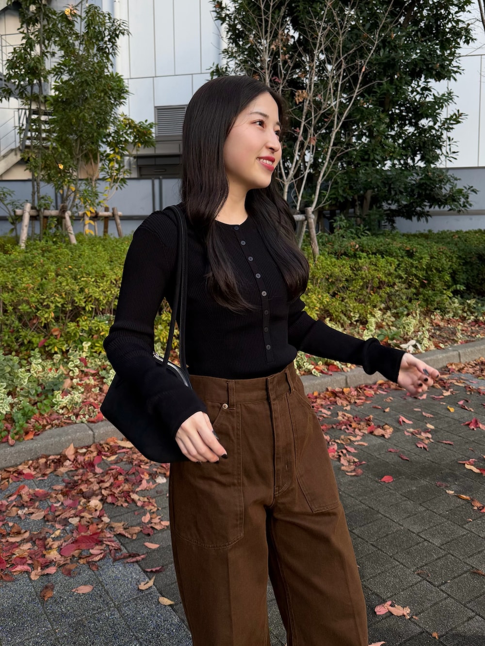 ブラック系のニット/セーター、ブラウン系のテーラードジャケット、ブラウン系のその他パンツを着用したレディースの秋コーディネートの2枚目の写真