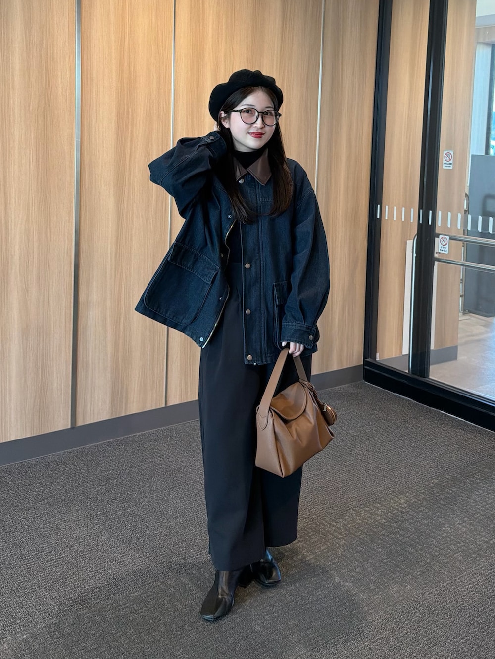 ブラック系のニット/セーター、ブラック系のブーツ、ブルー系のデニムジャケットを着用したレディースの冬コーディネートの2枚目の写真