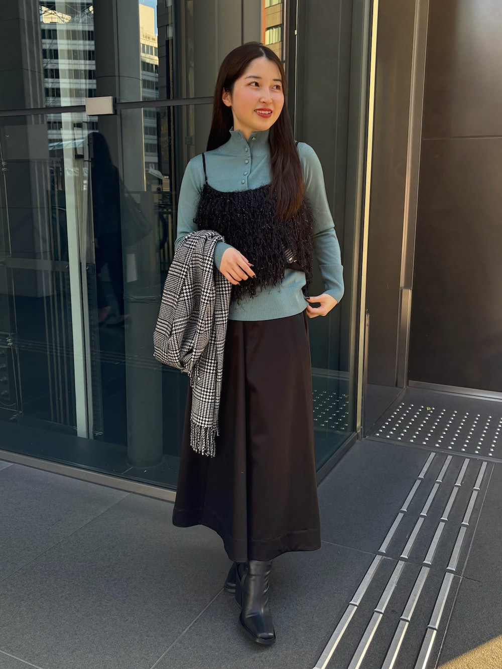 ブラック系のスカート、ブルー系のニット/セーター、ブラック系のシャツ/ブラウスを着用したレディースの冬コーディネートの5枚目の写真