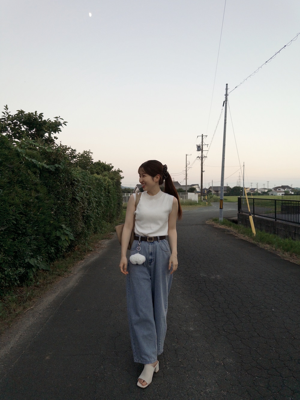 ホワイト系のニット/セーター、ブルー系のデニムパンツ、ホワイト系のサンダルを着用したレディースの夏コーディネートの5枚目の写真
