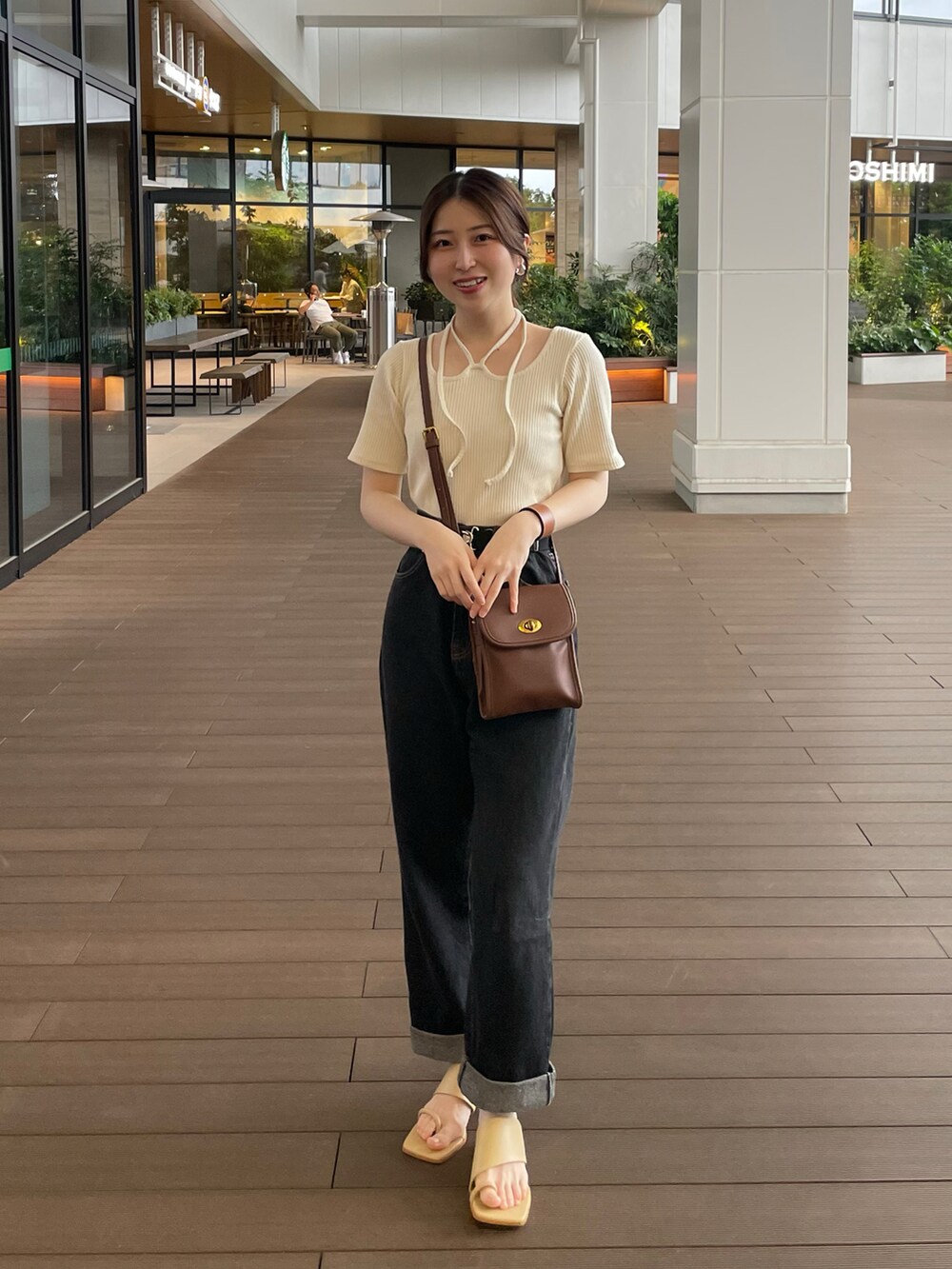 ホワイト系のTシャツ/カットソー、ブラック系のデニムパンツ、イエロー系のサンダルを着用したレディースの夏コーディネートの2枚目の写真