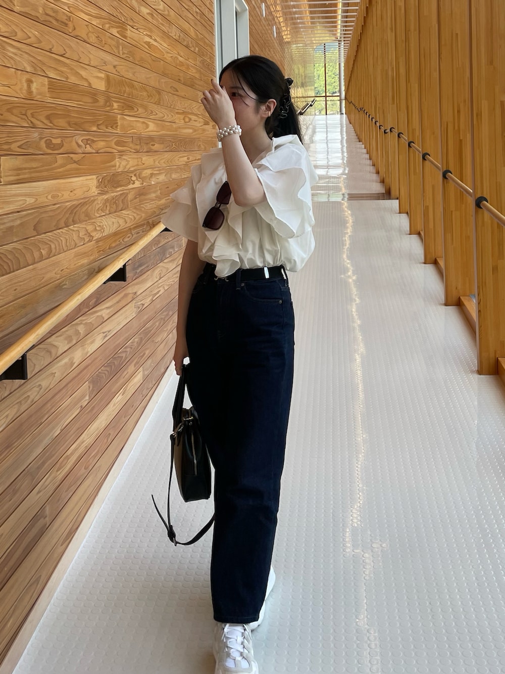 ホワイト系のシャツ/ブラウス、ブラック系のボストンバッグ、ホワイト系のスニーカーを着用したレディースの夏コーディネートの2枚目の写真