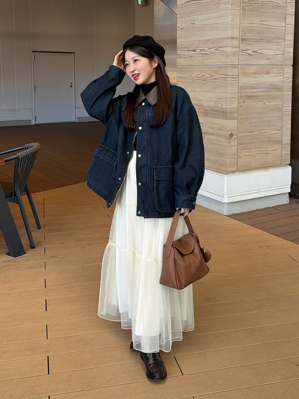 ブルー系のデニムジャケット、ブラック系のニット/セーター、ホワイト系のスカートを着用したレディースの冬コーディネートの5枚目の写真