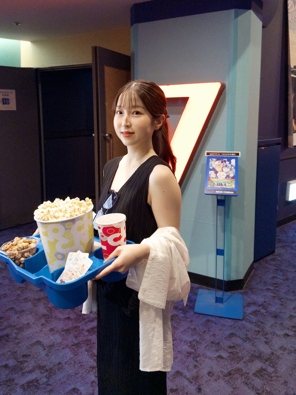 ブラック系のワンピース、ホワイト系のサンダル、ホワイト系のシャツ/ブラウスを着用したレディースの夏コーディネートの3枚目の写真