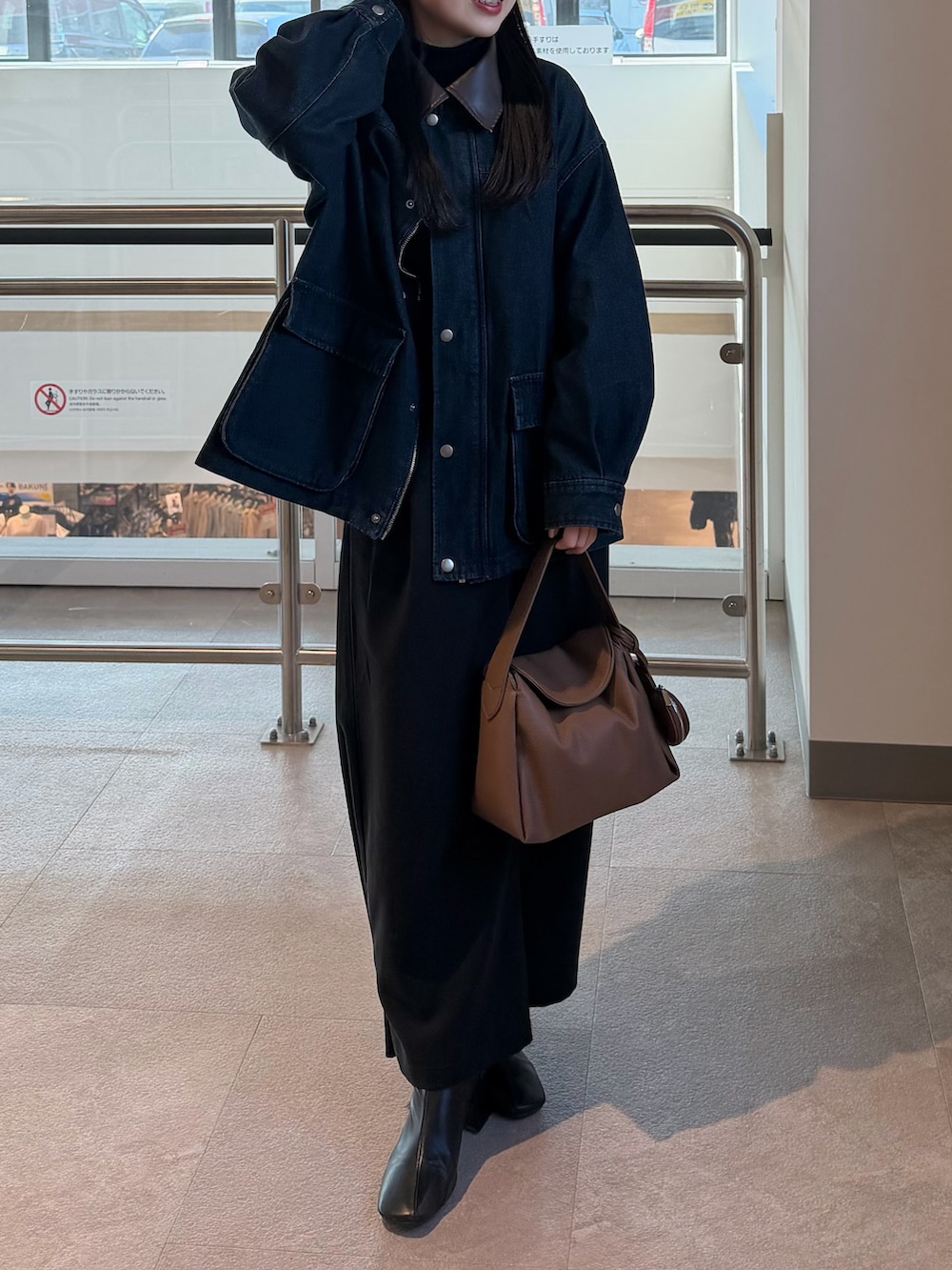 ブラック系のニット/セーター、ブラック系のブーツ、ブルー系のデニムジャケットを着用したレディースの冬コーディネートの4枚目の写真