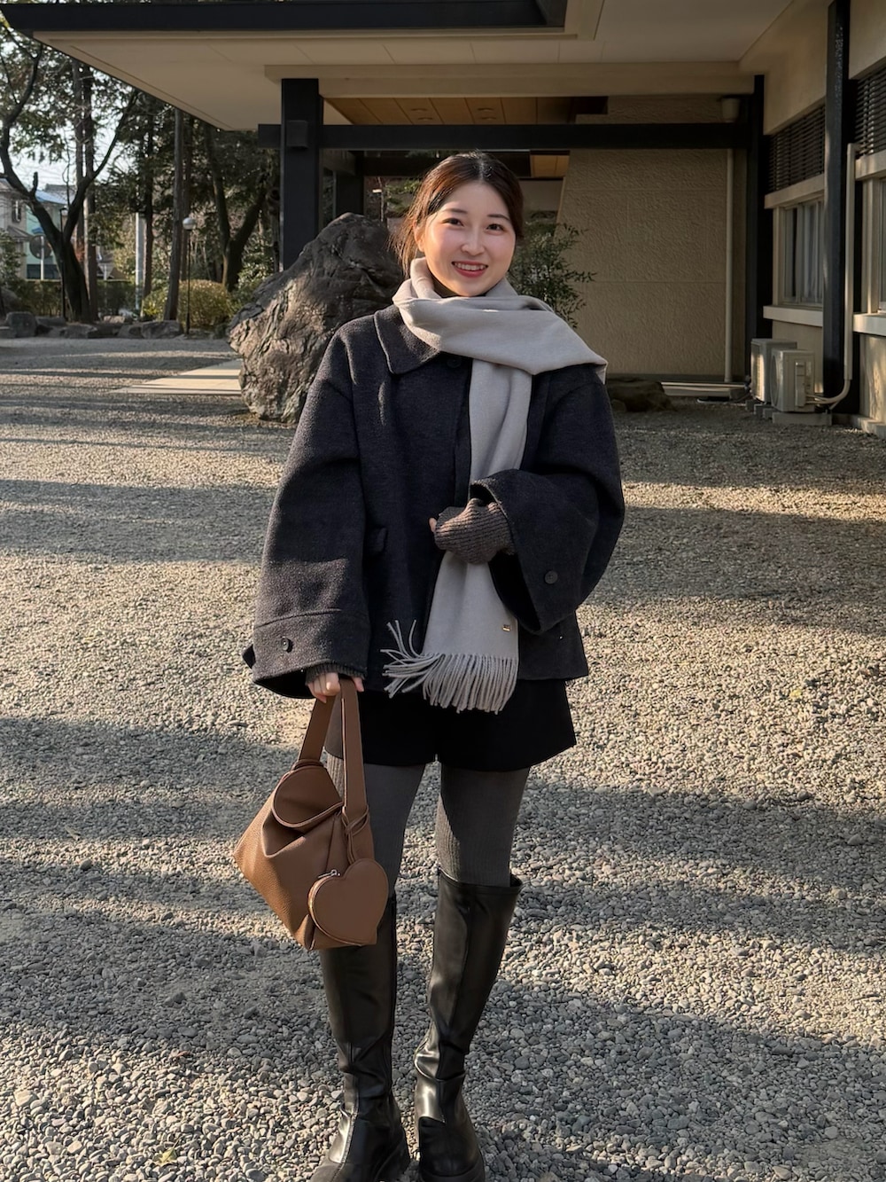 ブラック系のその他パンツ、グレー系のニット/セーター、イエロー系のハンドバッグを着用したレディースの冬コーディネートの3枚目の写真