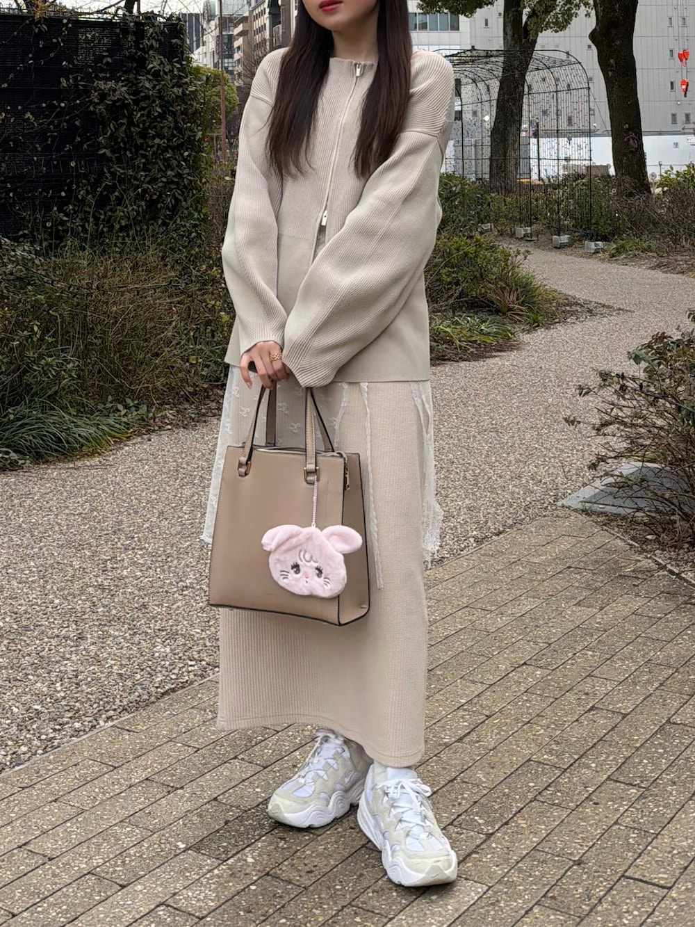 ベージュ系のカーディガン/ボレロ、ホワイト系のスニーカー、その他のスカートを着用したレディースの春コーディネートの5枚目の写真