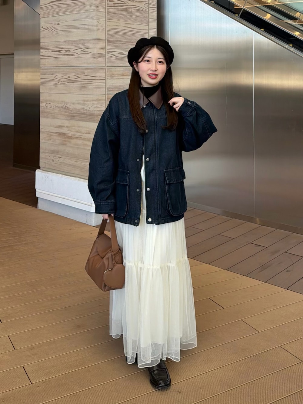 ブルー系のデニムジャケット、ブラック系のニット/セーター、ホワイト系のスカートを着用したレディースの冬コーディネートの2枚目の写真