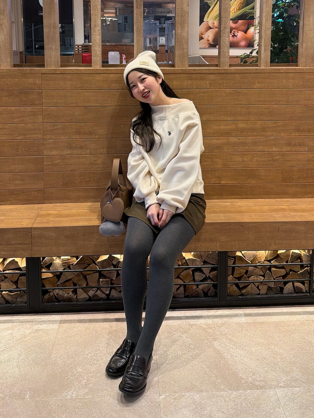 ホワイト系のスウェット、ブラウン系のスカート、イエロー系のハンドバッグを着用したレディースの冬コーディネートの5枚目の写真