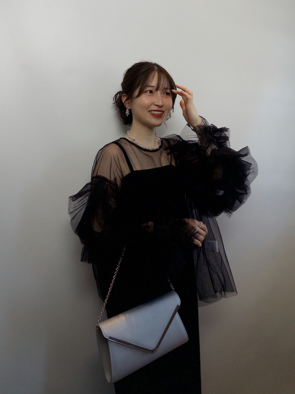 ブラック系のシャツ/ブラウス、シルバー系のハンドバッグ、ゴールド系のパンプスを着用したレディースの夏コーディネートの5枚目の写真