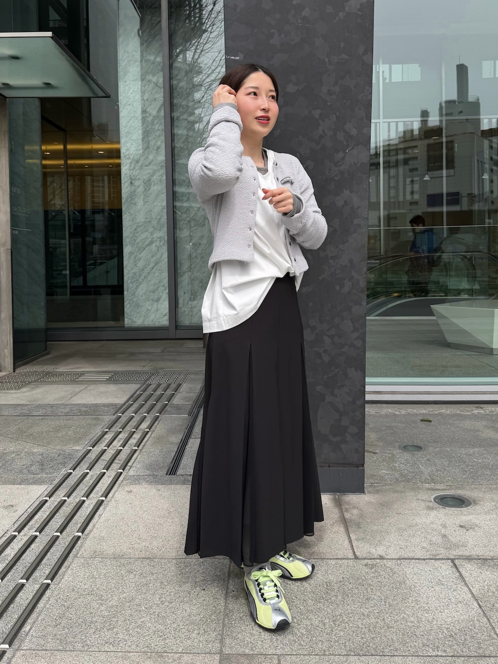 ホワイト系のTシャツ/カットソー、ブラック系のスカート、グレー系のカーディガン/ボレロを着用したレディースの春コーディネートの2枚目の写真