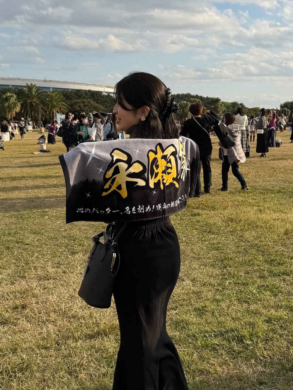 ブラック系のスカート、グレー系のニット/セーター、ブラック系のブーツを着用したレディースの秋コーディネートの3枚目の写真