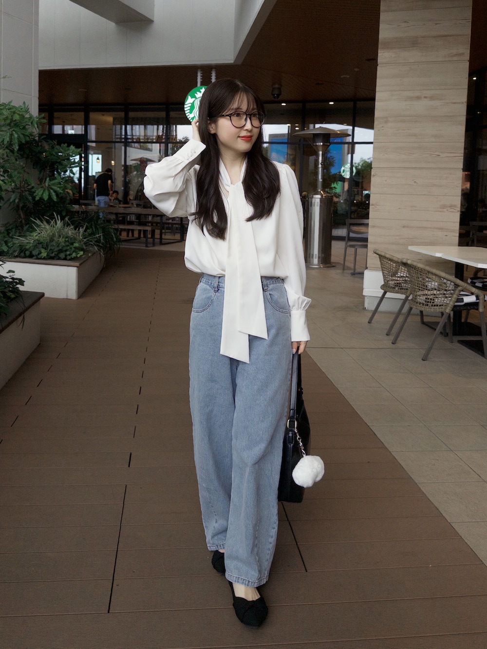ホワイト系のシャツ/ブラウス、ブルー系のデニムパンツ、ブラック系のハンドバッグを着用したレディースの夏コーディネートの2枚目の写真
