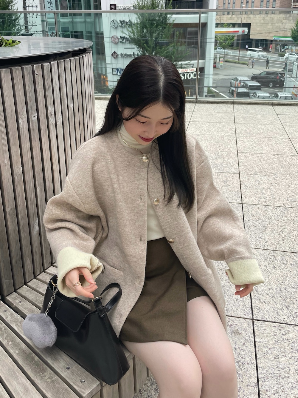 ベージュ系のカーディガン/ボレロ、ブラック系のブーツ、ホワイト系のTシャツ/カットソーを着用したレディースの秋コーディネートの2枚目の写真