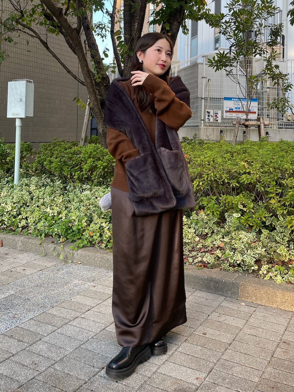 ブラック系のブーツ、ブラウン系のニット/セーター、ブラウン系のスカートを着用したレディースの秋コーディネートの2枚目の写真