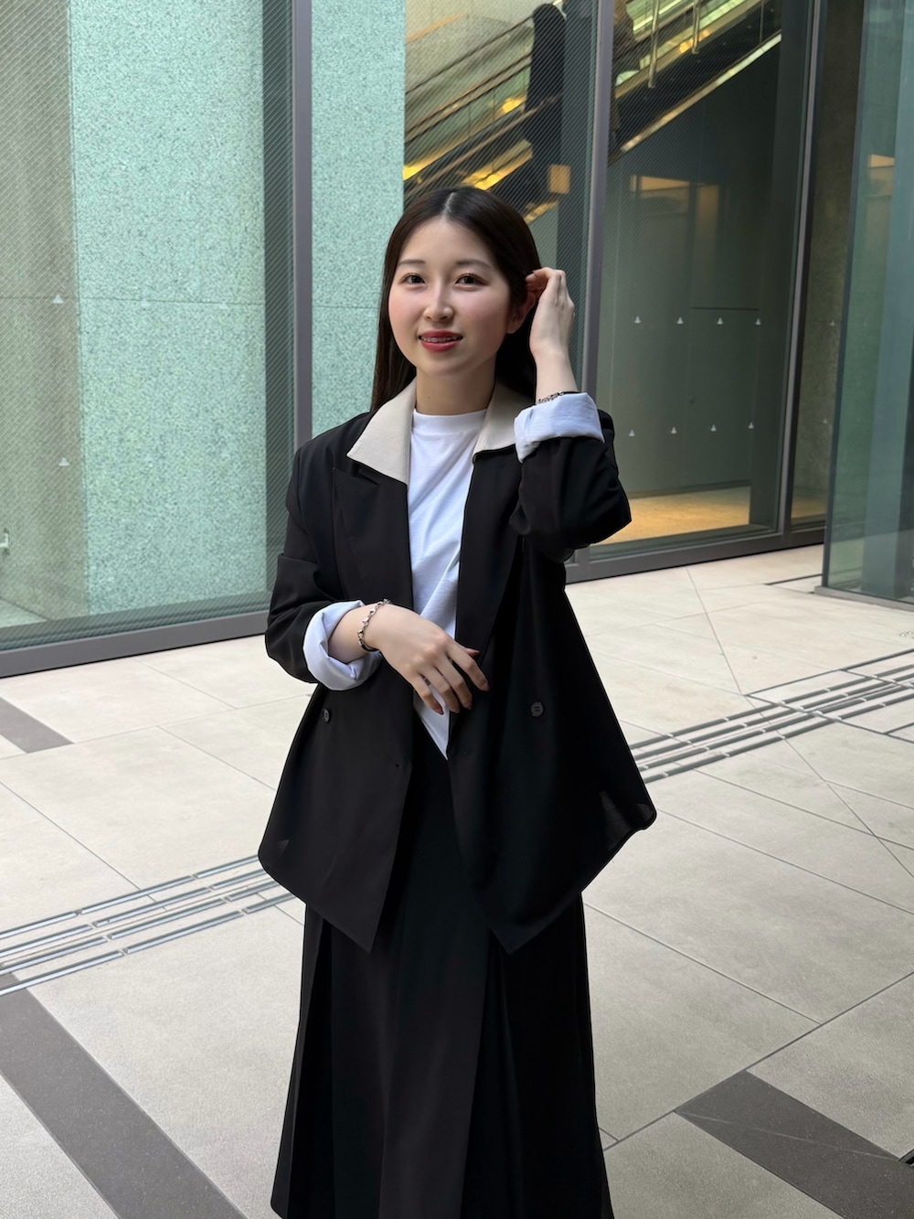 ホワイト系のTシャツ/カットソー、ブラック系のテーラードジャケット、ブラック系のスカートを着用したレディースの春コーディネートの5枚目の写真