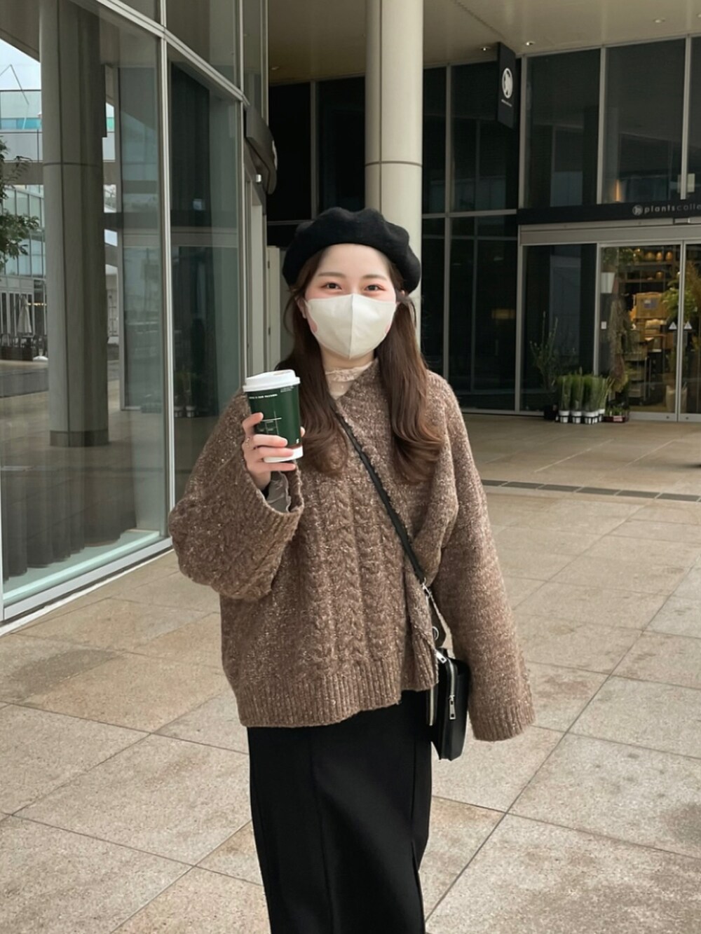 ブラウン系のニット/セーター、ブラック系のジャンパースカート、ブラック系のドレスシューズを着用したレディースの冬コーディネートの2枚目の写真