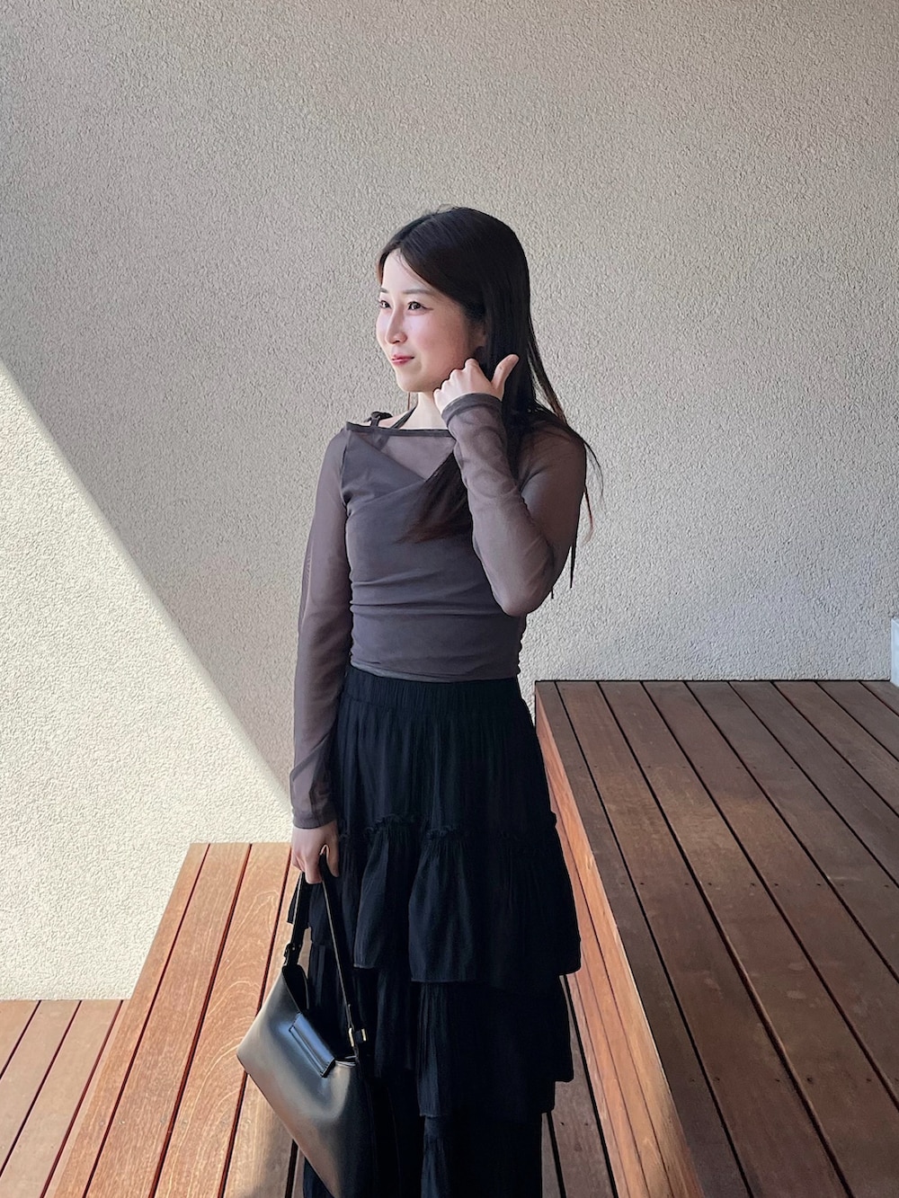 グレー系のTシャツ/カットソー、ブラック系のスカート、ブラック系のパンプスを着用したレディースの春コーディネートの2枚目の写真