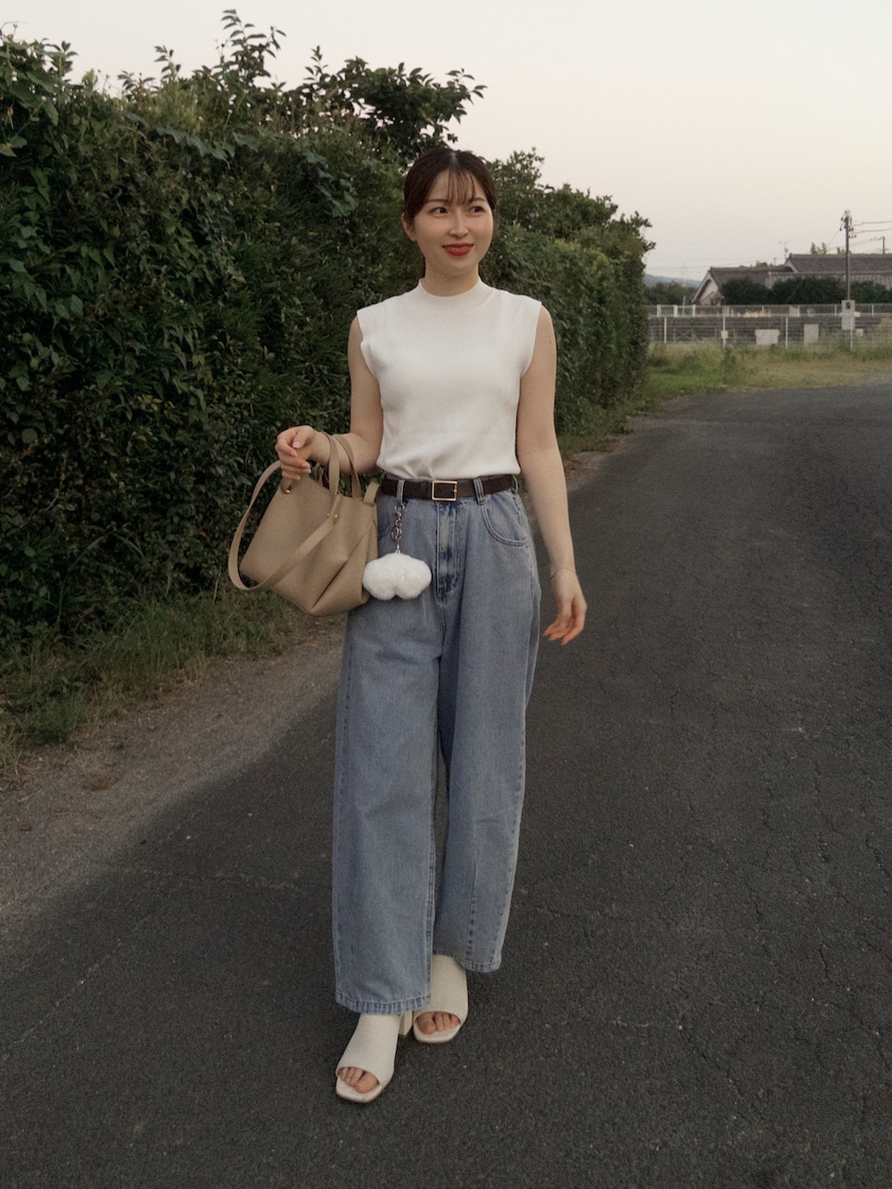 ホワイト系のニット/セーター、ブルー系のデニムパンツ、ホワイト系のサンダルを着用したレディースの夏コーディネートの2枚目の写真