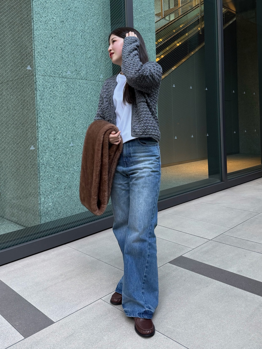 グレー系のニット/セーター、ブルー系のその他パンツ、ホワイト系のTシャツ/カットソーを着用したレディースの冬コーディネートの5枚目の写真