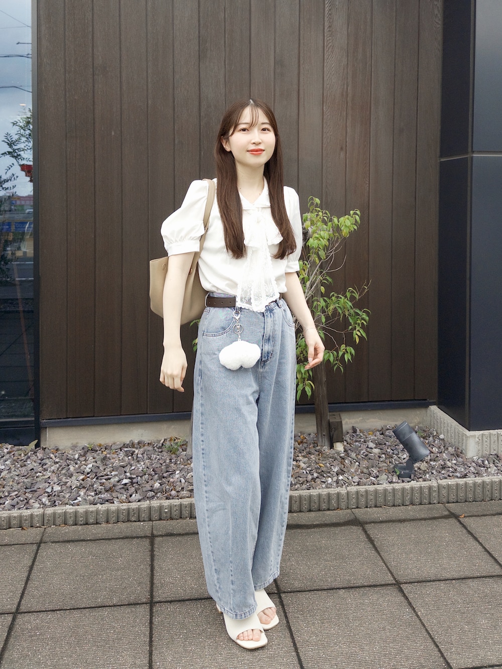 ホワイト系のシャツ/ブラウス、ブルー系のデニムパンツ、ベージュ系のトートバッグを着用したレディースの夏コーディネートの3枚目の写真