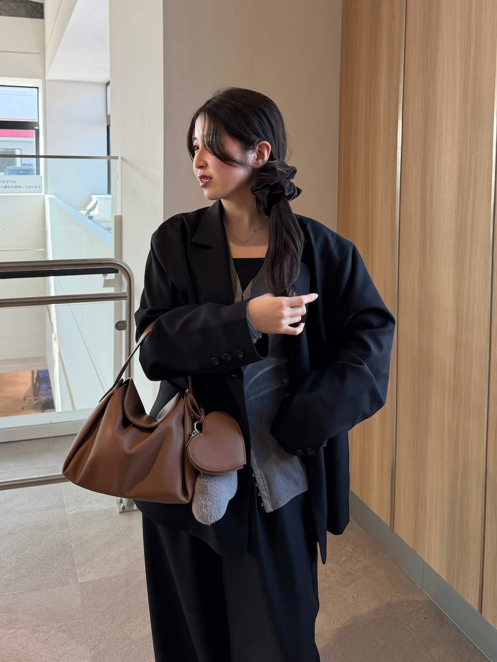 ブラック系のテーラードジャケット、グレー系のTシャツ/カットソー、ブラック系のスラックスを着用したレディースの冬コーディネートの4枚目の写真