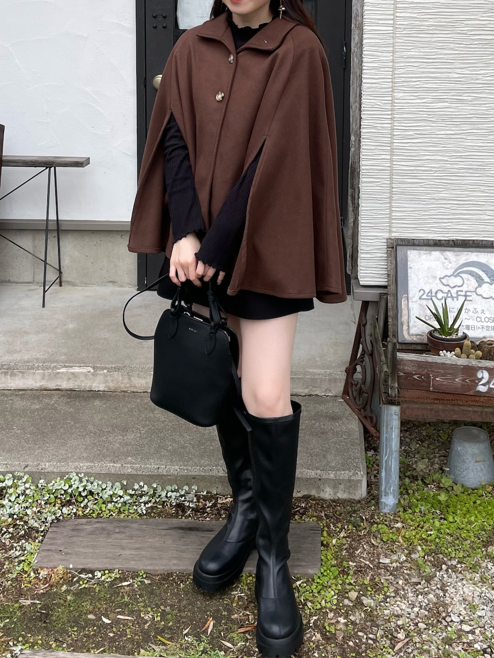 ブラウン系のポンチョ、ブラック系のその他パンツ、ブラック系のブーツを着用したレディースの秋コーディネートの3枚目の写真