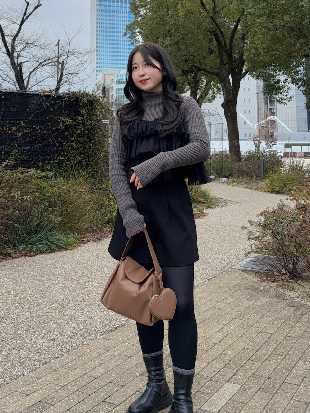 ブラック系のその他アウター、ブラック系のその他パンツ、ブラック系のブーツを着用したレディースの冬コーディネートの2枚目の写真