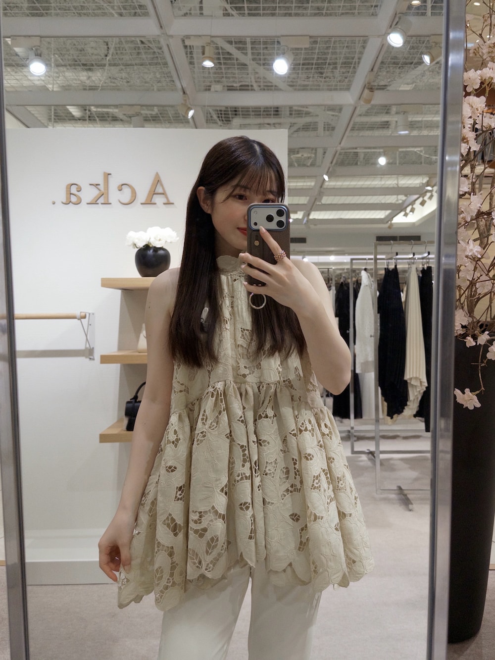 ベージュ系のトップス、ホワイト系のパンツ、ブラック系のパンプスを着用したレディースの春コーディネートの3枚目の写真