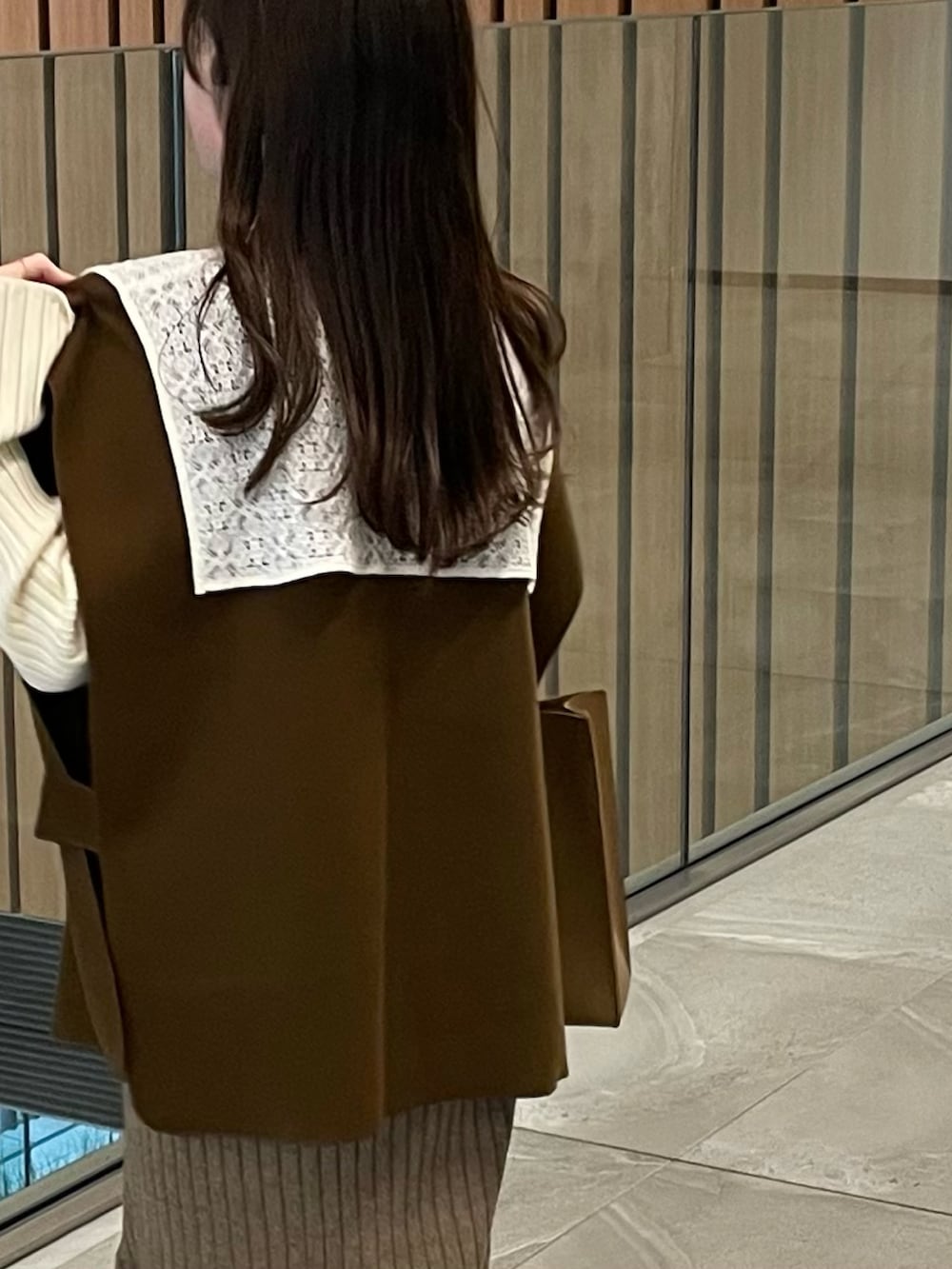 ホワイト系のニット/セーター、ブラウン系のベスト、ブラウン系のスカートを着用したレディースの冬コーディネートの3枚目の写真