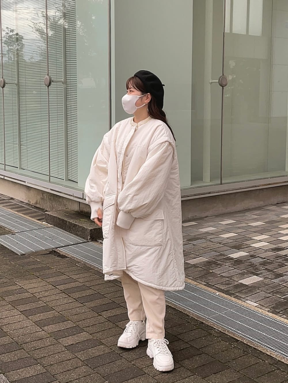 ホワイト系のモッズコート、ホワイト系のパンツ、ホワイト系のスニーカーを着用したレディースの冬コーディネートの2枚目の写真