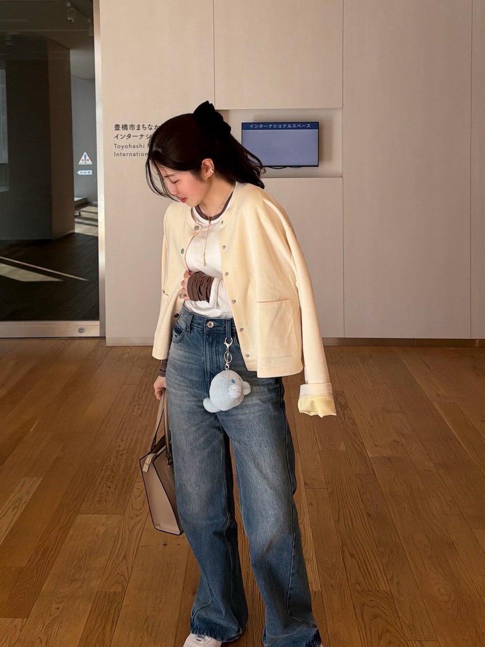 ホワイト系のカーディガン/ボレロ、ブルー系のその他パンツ、グレー系のスニーカーを着用したレディースの冬コーディネートの3枚目の写真