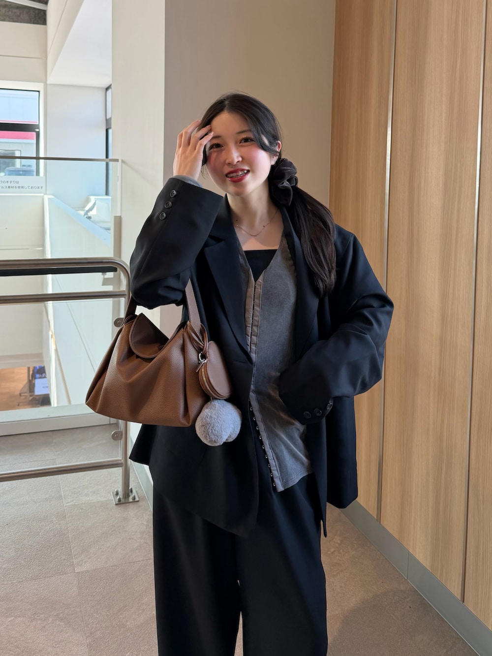 ブラック系のテーラードジャケット、グレー系のTシャツ/カットソー、ブラック系のスラックスを着用したレディースの冬コーディネートの3枚目の写真