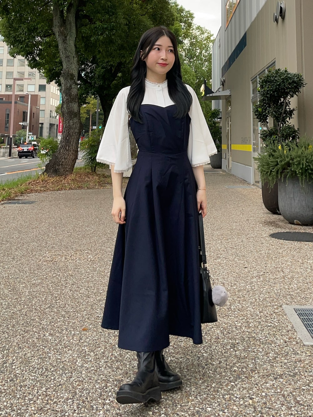 ブラック系のブーツ、ホワイト系のシャツ/ブラウス、ブルー系のワンピースを着用したレディースの秋コーディネートの2枚目の写真