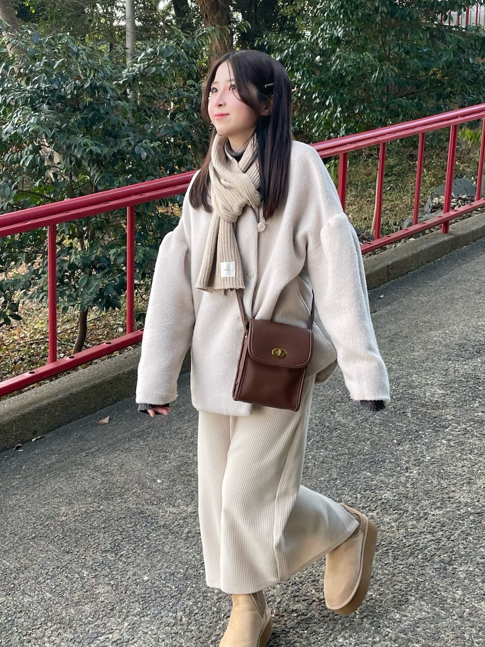 グレー系のニット/セーター、ホワイト系のスカート、ベージュ系のブーツを着用したレディースの冬コーディネートの2枚目の写真