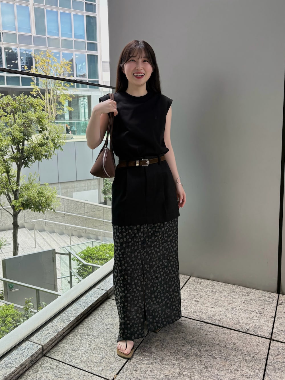 ブラウン系のビジネスバッグ、ブラック系のTシャツ/カットソー、ブラック系のスカートを着用したレディースの春コーディネートの4枚目の写真