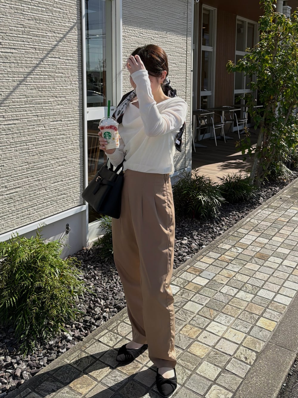 ホワイト系のキャミソール、ホワイト系のTシャツ/カットソー、ブラック系のショルダーバッグを着用したレディースの春コーディネートの4枚目の写真